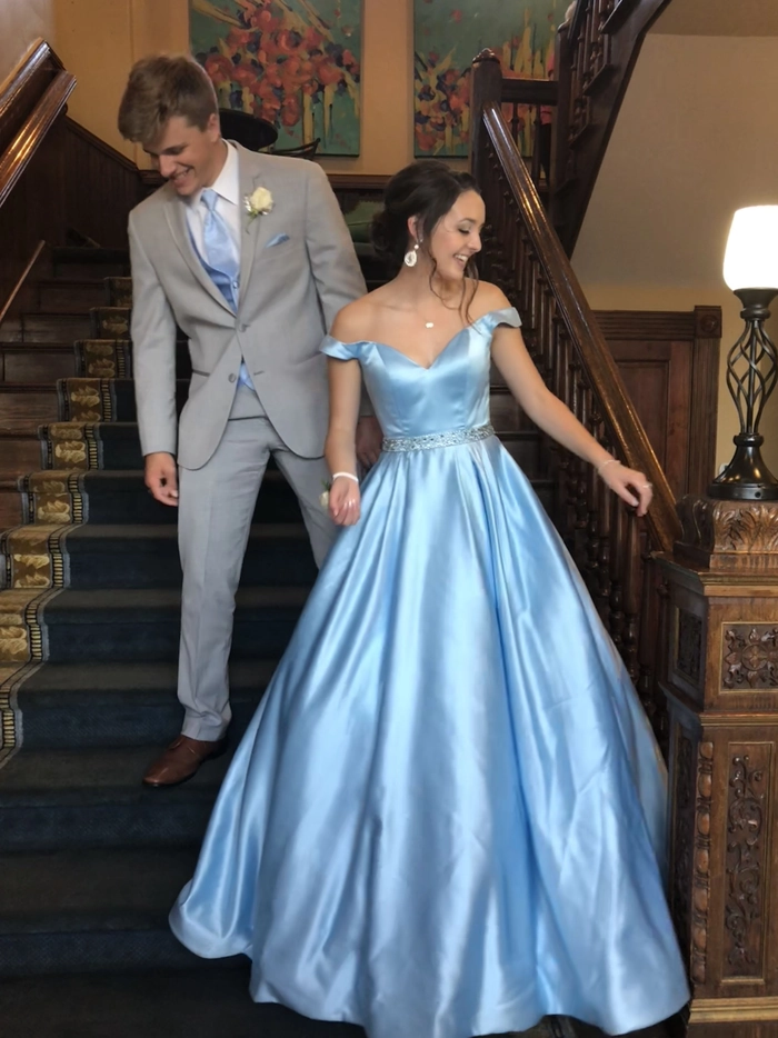Elegant curly updo showcasing prom hairstyles to match a blue dress