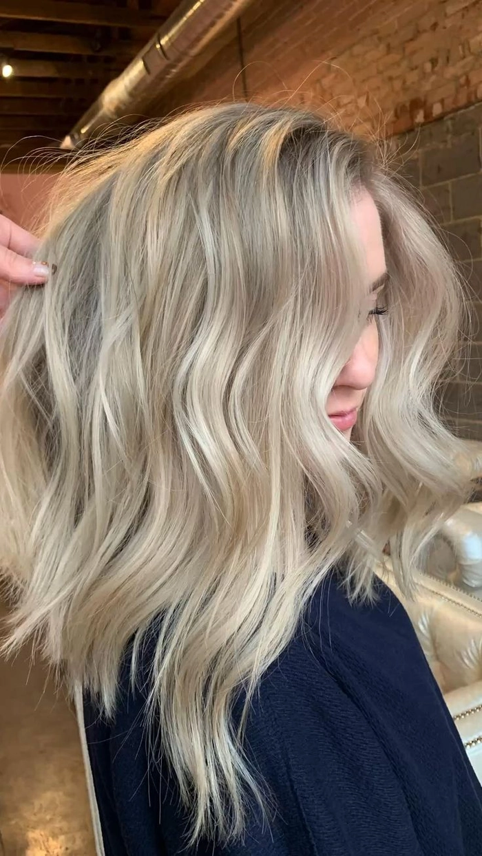 Elegant prom hairstyle featuring ash blonde highlights in loose curls