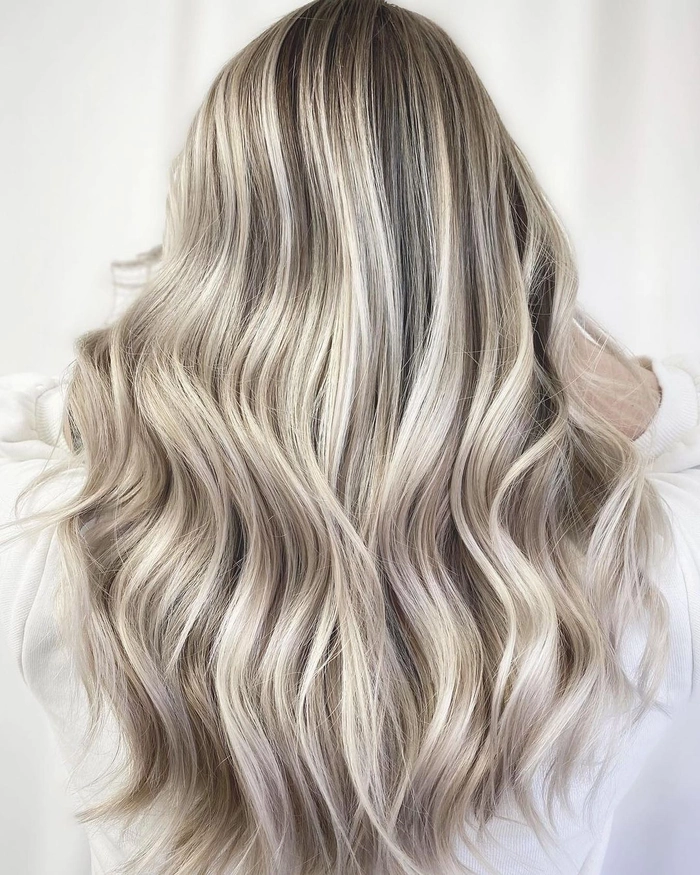 Elegant prom hairstyle featuring ash blonde highlights in soft curls
