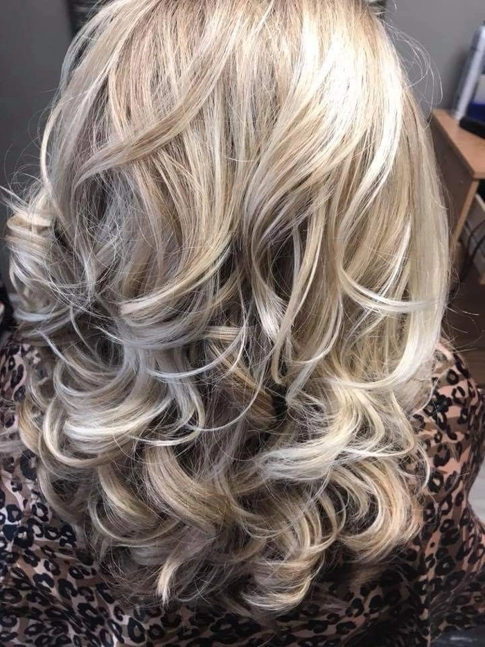 Elegant prom hairstyle featuring ash blonde highlights on curled hair