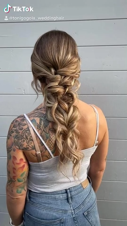 Elegant loose curls with floral accents perfect for prom hairstyles for a rustic barn venue