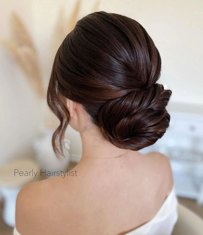 Sophisticated low chignon hairstyle perfect for prom night glamour Elegant low chignon prom updo with soft waves and delicate tendrils