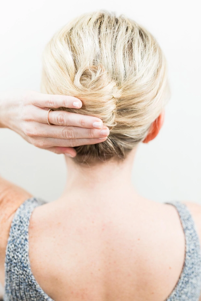 Elegant messy French twist prom hairstyle with loose tendrils