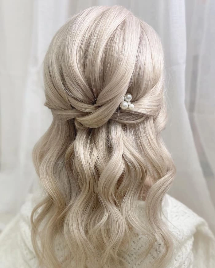 Elegant prom hairstyle on platinum blonde hair with soft curls and volume