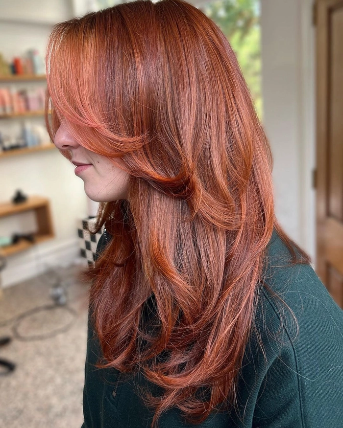 Elegant prom hairstyle with copper ginger hair styled in soft waves
