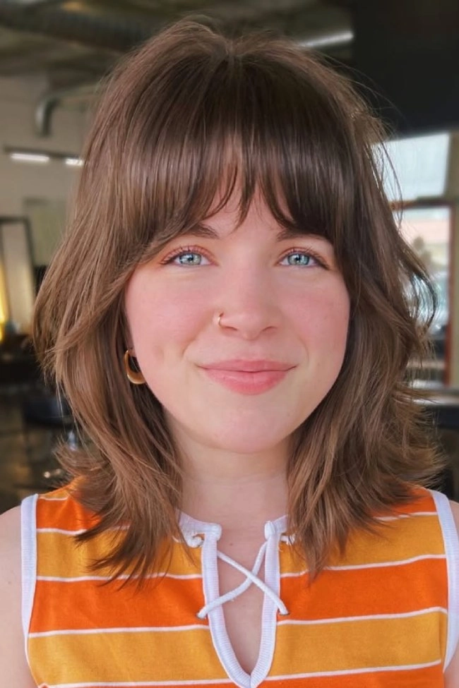 Chic prom look with curtain fringe and styled bangs for a memorable night Elegant prom hairstyle featuring bangs and a flowing curtain fringe