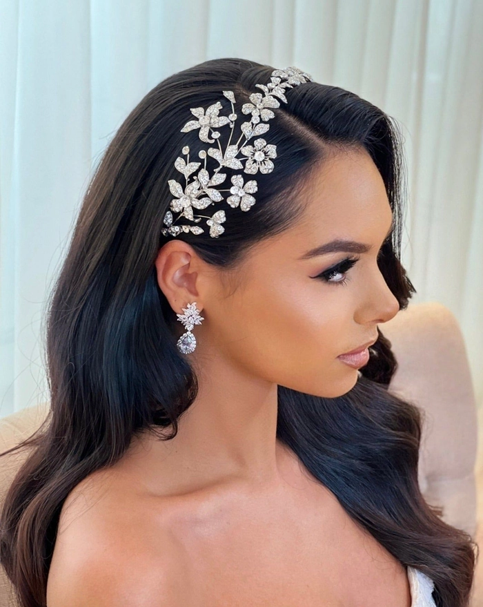 Sophisticated prom look with sparkling crystal accessory and flowing hair Elegant prom hairstyle featuring a crystal headband and soft curls