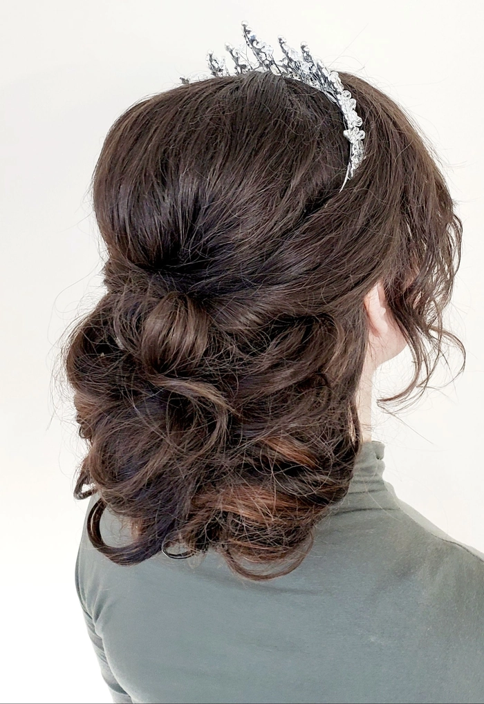 Prom hairstyle inspiration featuring a soft updo with a dainty tiara accessory Elegant prom hairstyle adorned with a delicate tiara for a stunning look