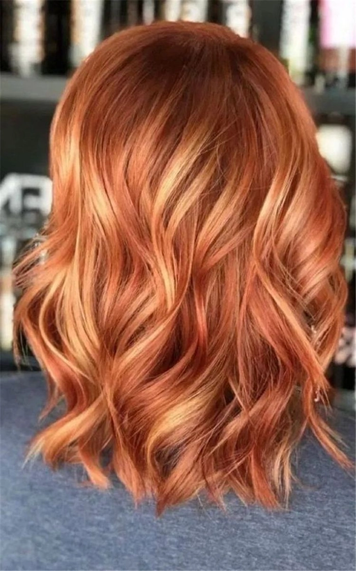 Elegant prom hairstyle featuring copper ginger hair with soft curls and floral accents
