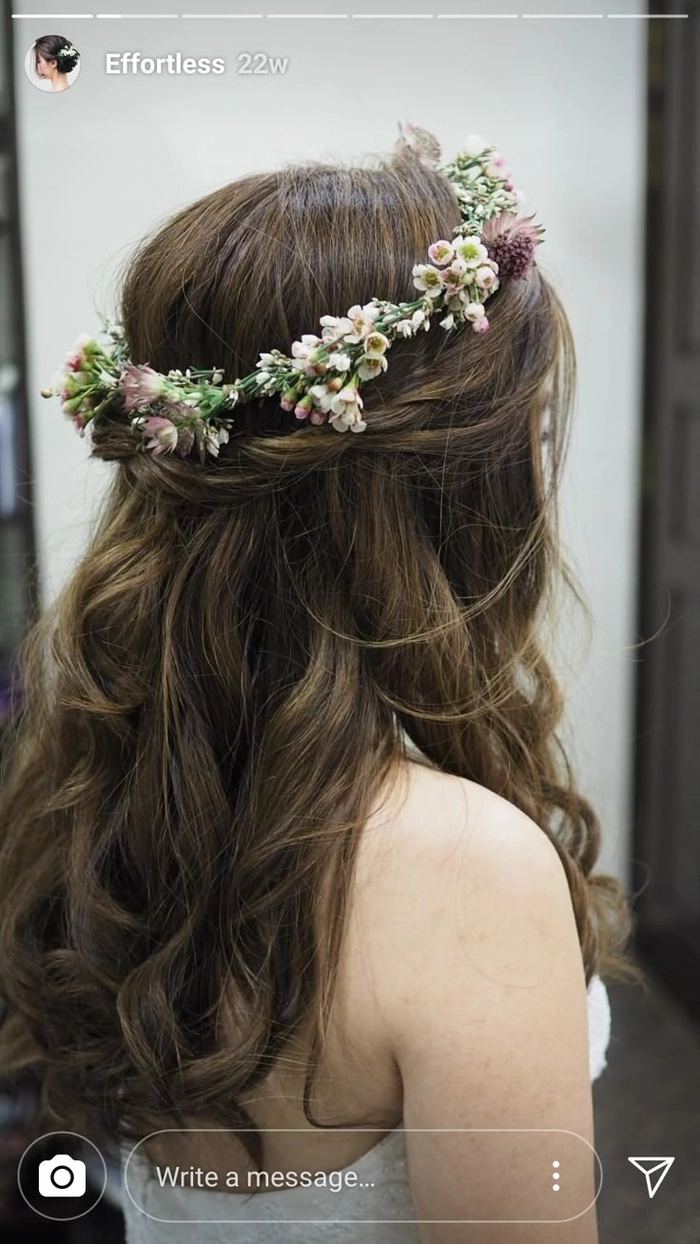 Elegant prom hairstyle adorned with fresh flower crown in soft pastel colors