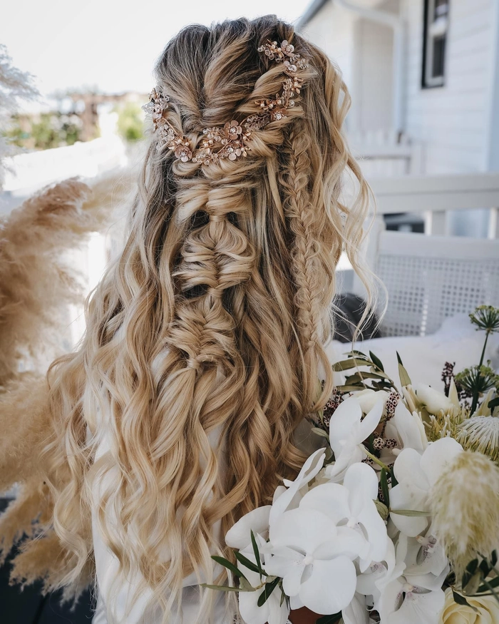Elegant prom hairstyle featuring loose curls and flowers, perfect for a rustic barn venue