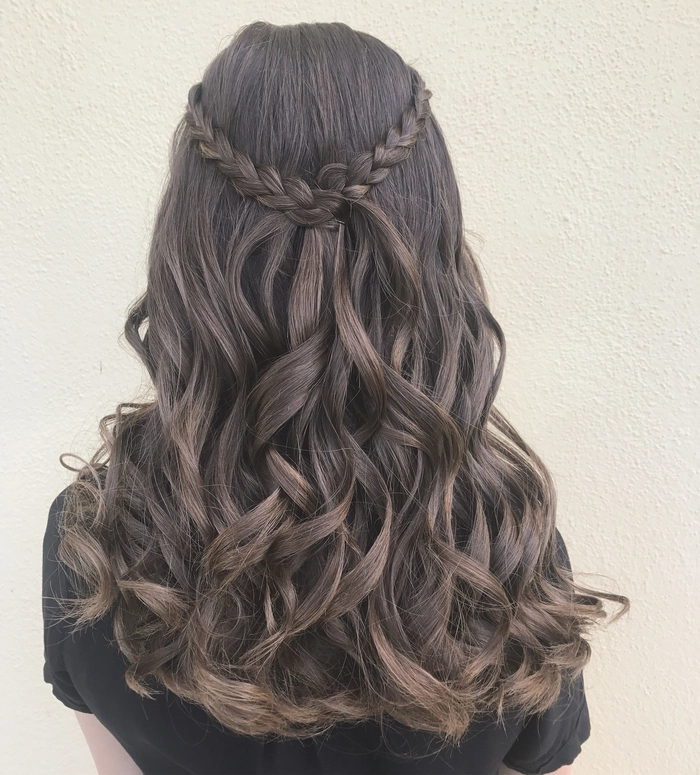 Stunning long wavy prom hairstyle perfect for a memorable evening celebration Elegant prom hairstyle for long wavy hair with soft curls and floral accessories