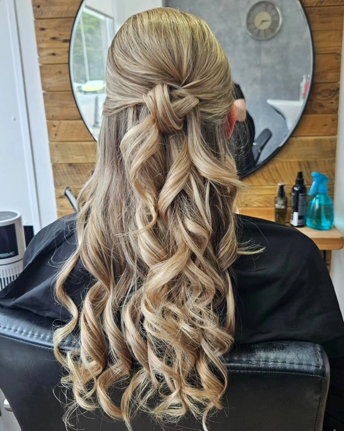 Elegant prom hairstyle featuring soft curls and a velvet ribbon accessory