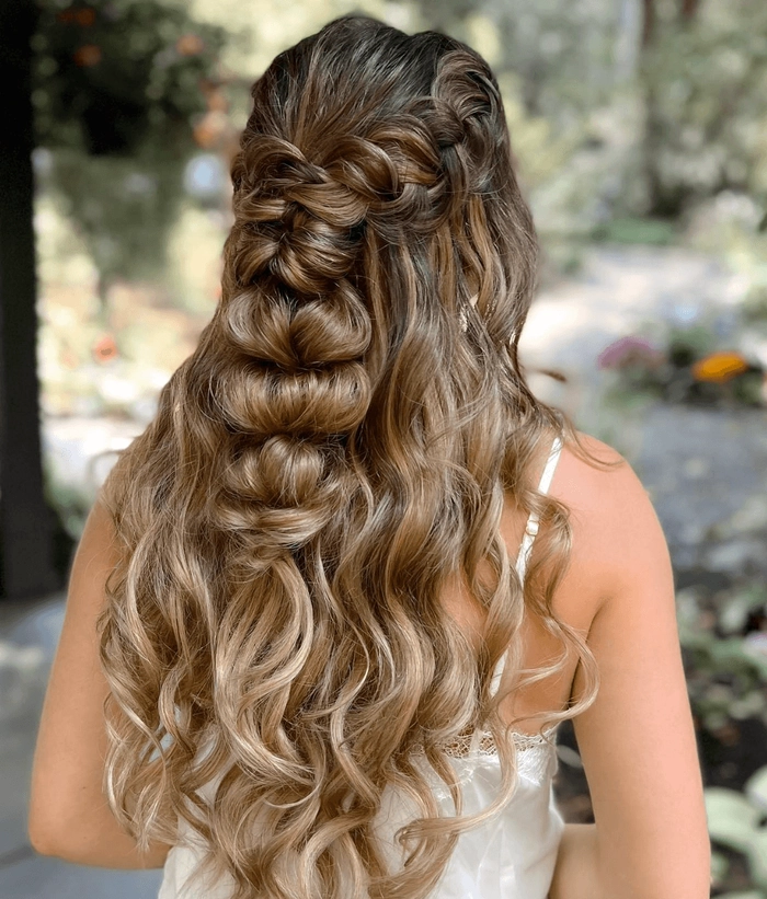 Elegant prom hairstyle featuring soft curls in a grand ballroom setting