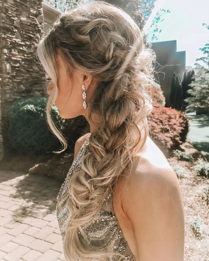 Elegant prom hairstyle featuring a single thick braid styled with soft waves