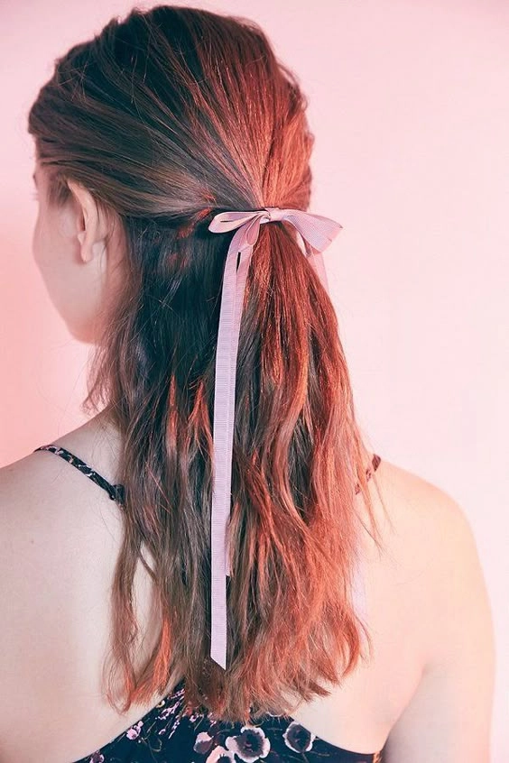 Elegant prom hairstyle featuring velvet ribbons braided into loose curls