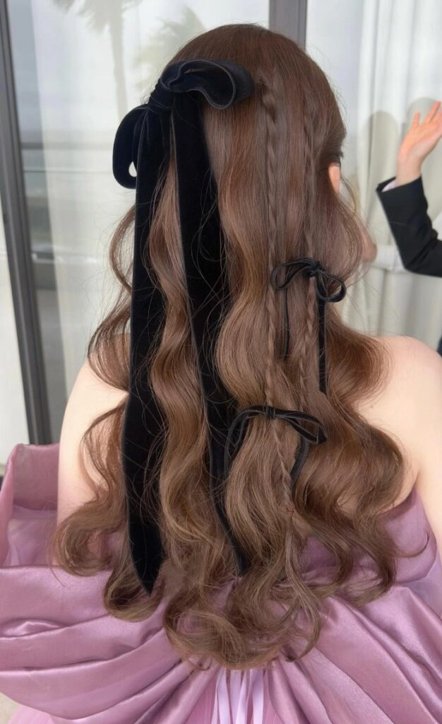 Elegant prom hairstyle featuring velvet ribbons woven through curls