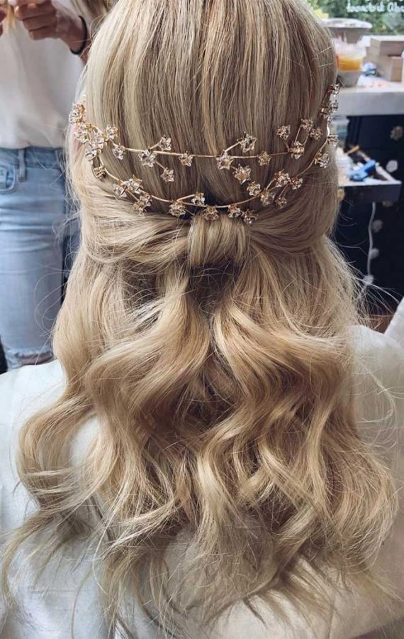 Elegant prom hairstyle featuring loose curls and floral accents for a rustic barn venue