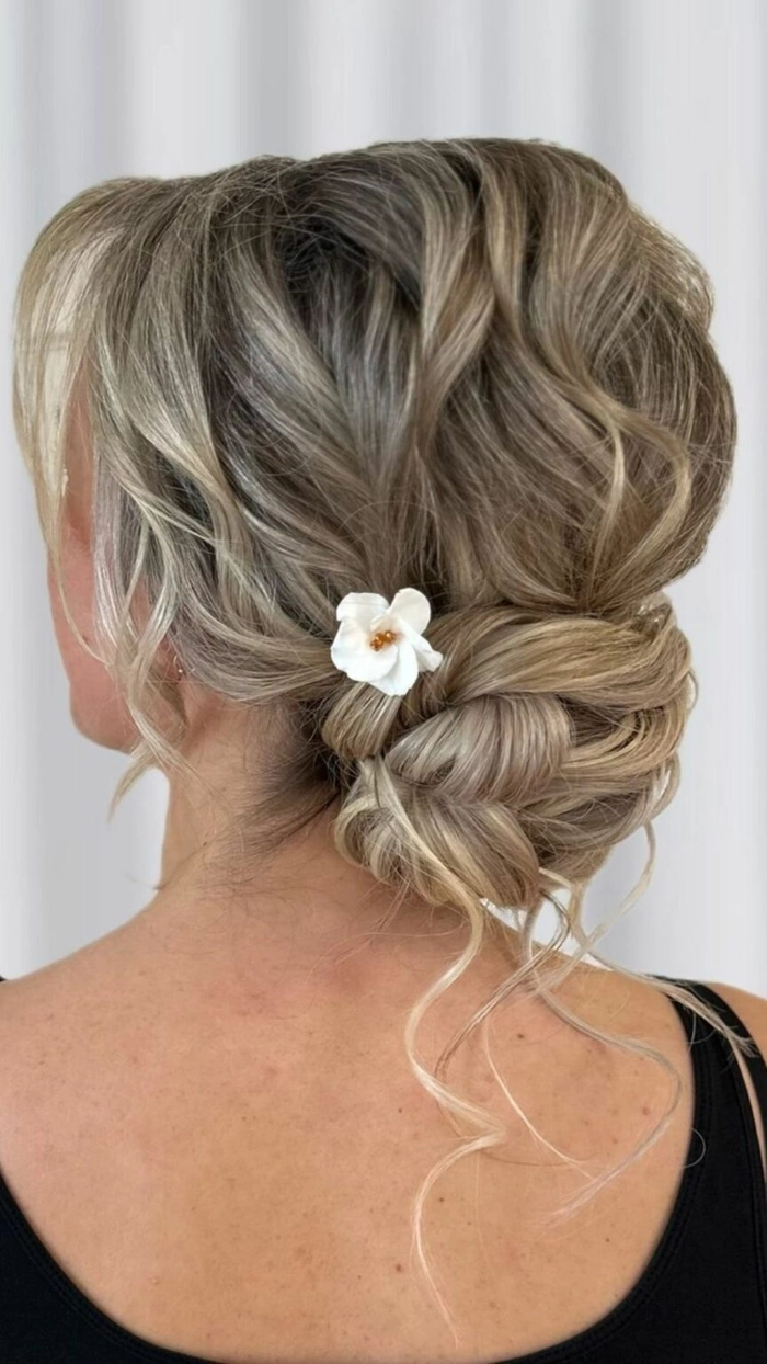 Elegant prom hairstyle featuring a low nape bun with delicate curls