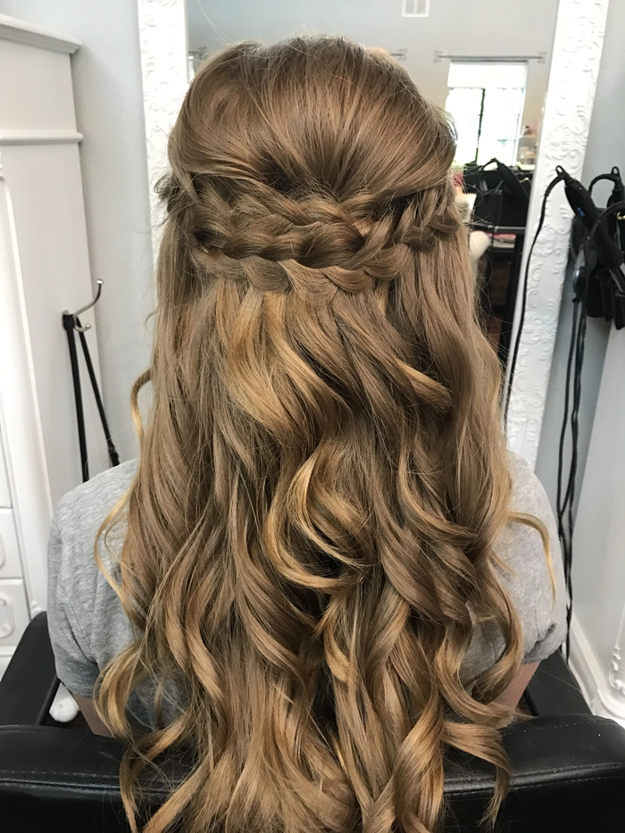 Elegant prom hairstyle featuring multiple small braids woven into an updo