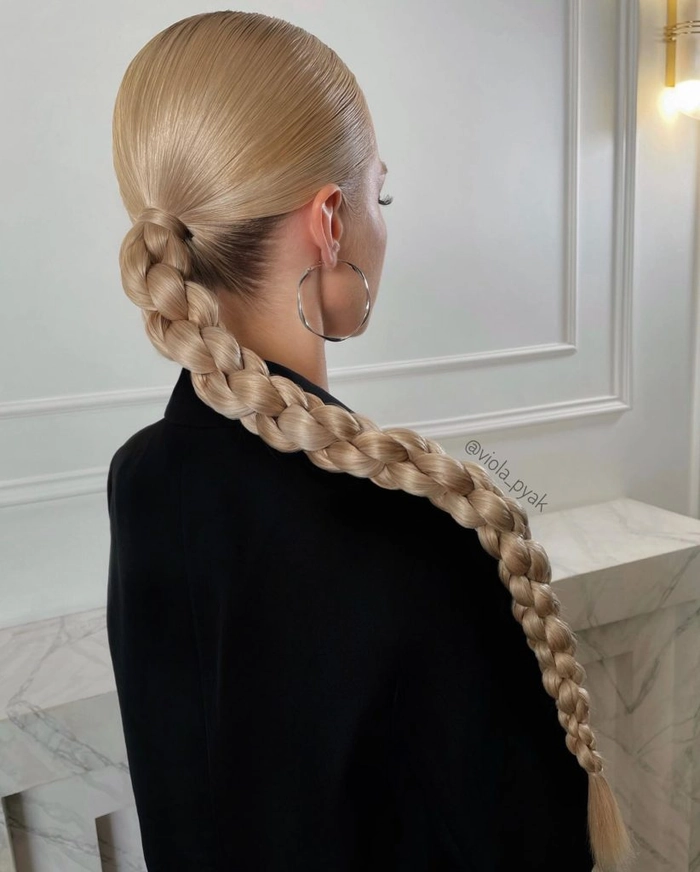 Elegant prom hairstyle featuring a single thick braid cascading over the shoulder