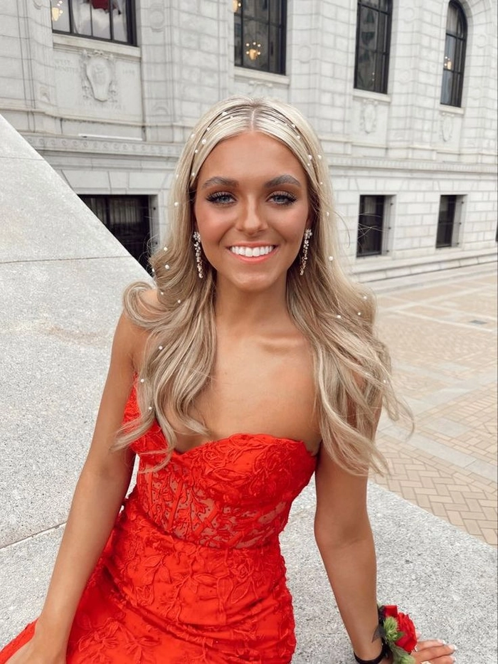 Elegant prom updo with soft curls styled to complement a red dress