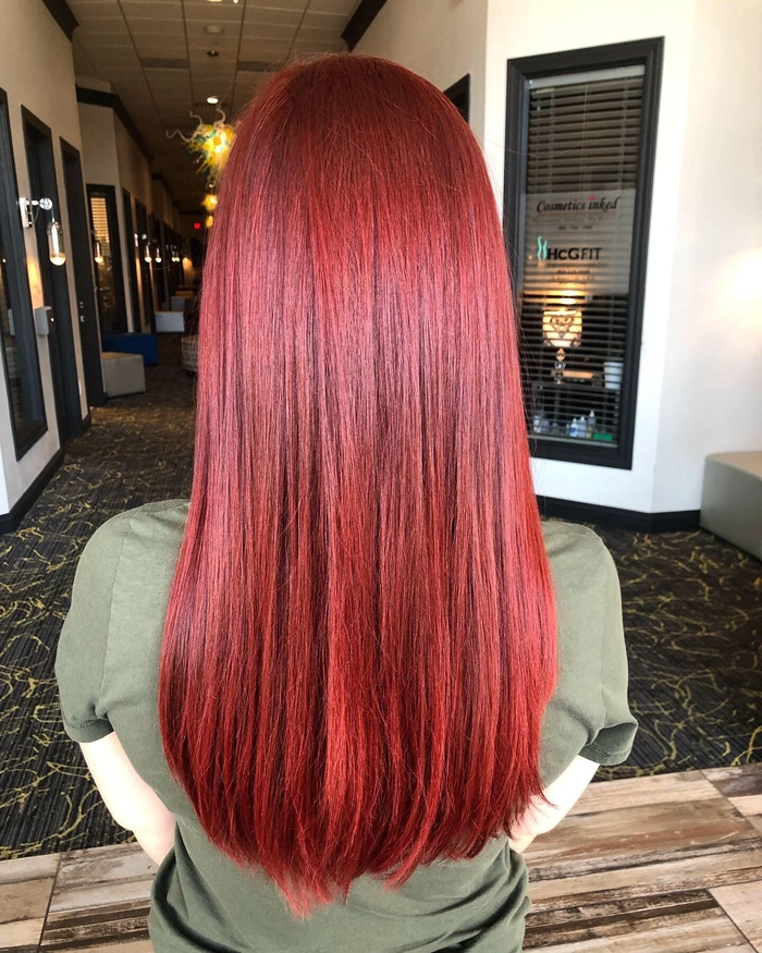 Elegant prom hairstyle featuring vibrant red hair styled in loose curls