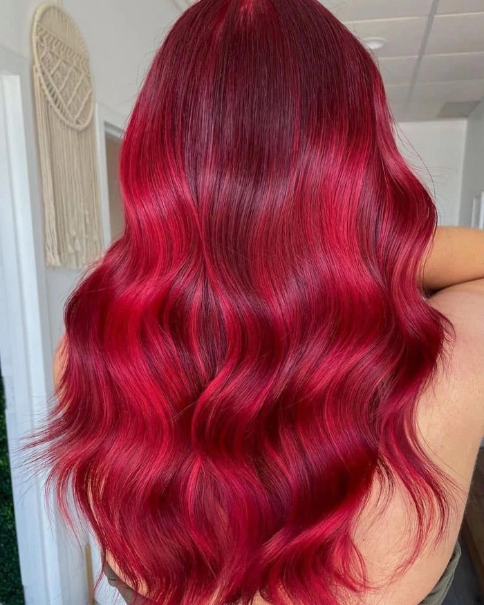 Elegant prom hairstyle for vibrant red hair with soft curls and a braided crown