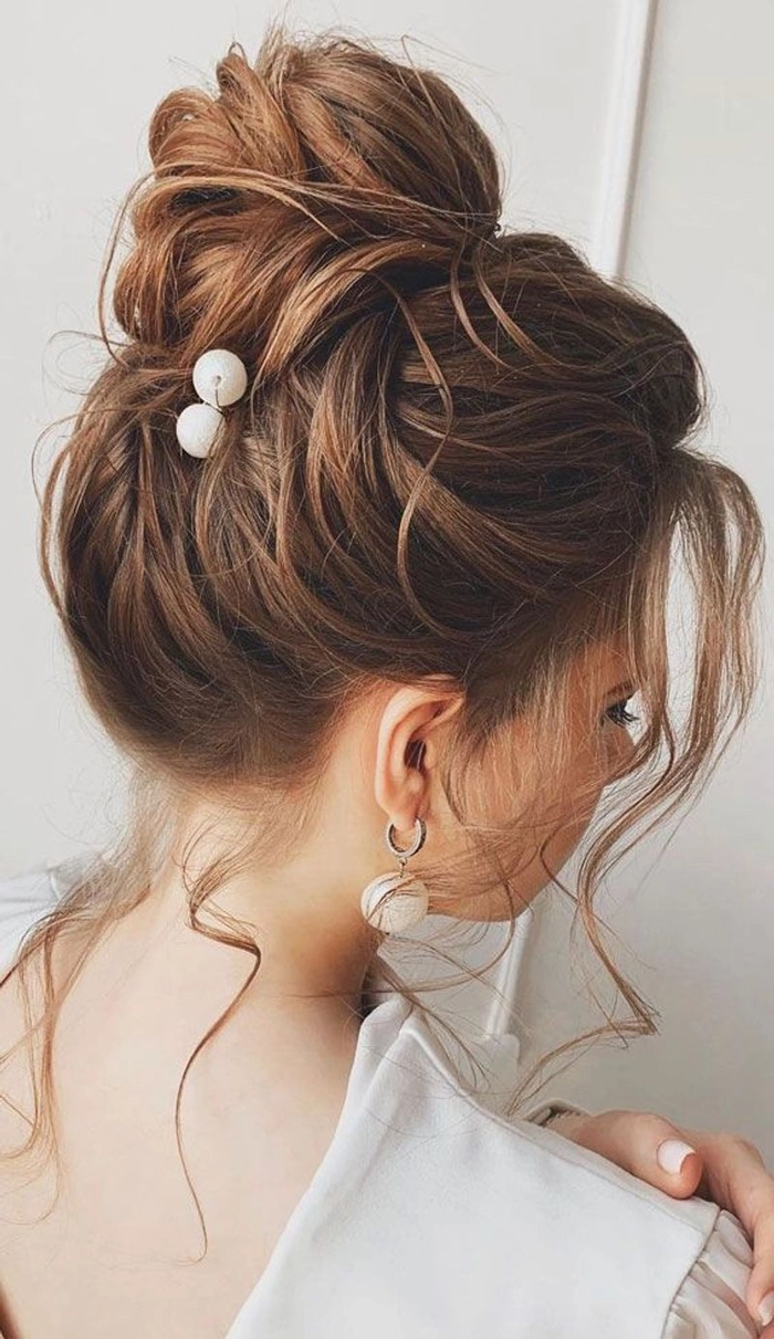 Stylish textured top knot hairstyle perfect for prom night glamour Elegant textured top knot prom updo with soft waves and volume