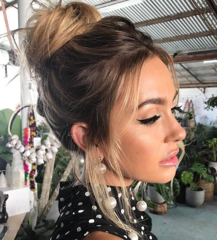 Chic textured top knot updo perfect for a modern prom hairstyle look Elegant textured top knot prom updo styled with volume and loose strands