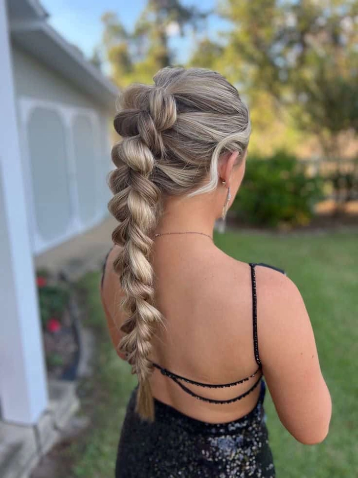 Elegant prom hairstyle featuring a single thick braid cascading over one shoulder