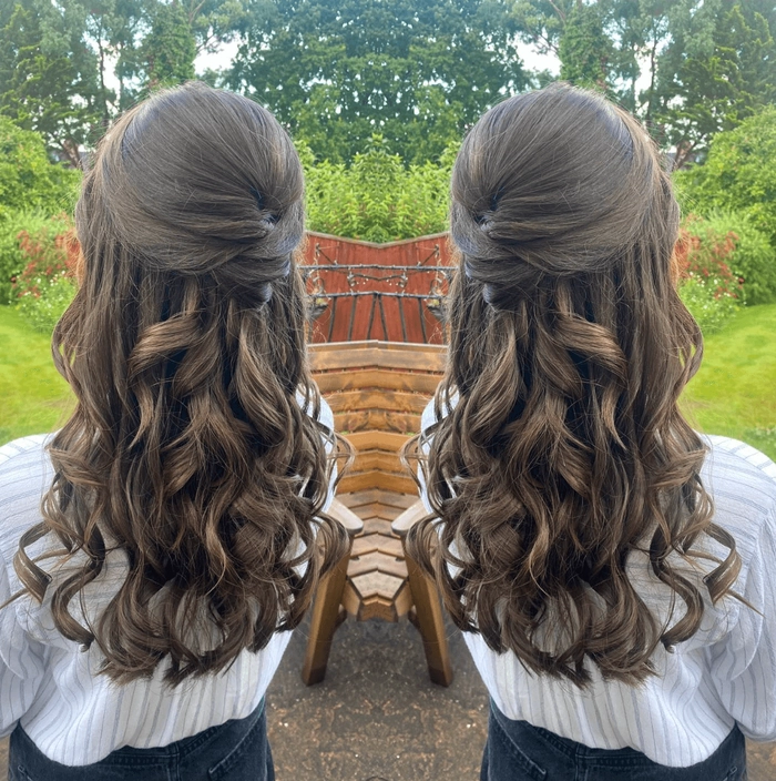 Elegant updo featuring intricate curls styled for prom in a grand ballroom setting