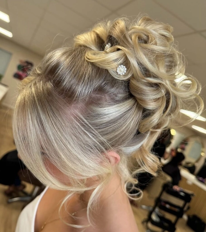 Elegant updo for prom hairstyles in a grand ballroom setting showcasing intricate curls