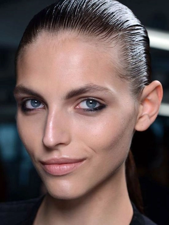 Elegant wet look slicked back prom hairstyle on a young woman