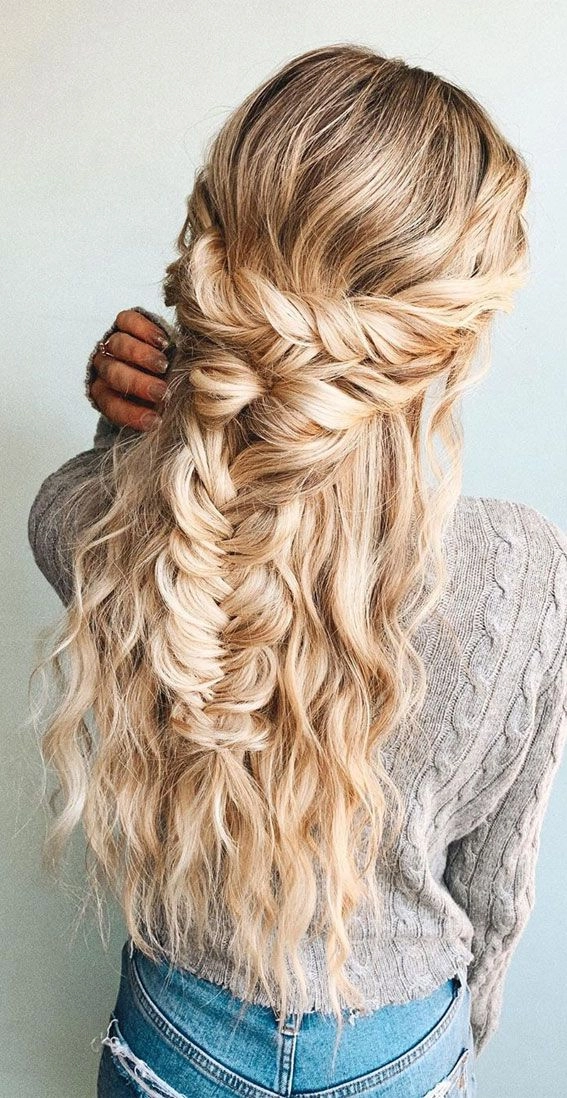 A fishtail braid prom hairstyle adorned with tiny white flowers