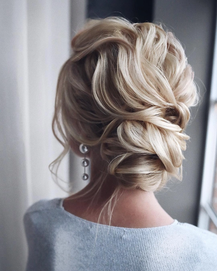 Sophisticated prom hairstyle showcasing a voluminous updo for medium thick hair Elegant medium length prom updo for thick hair with soft curls and volume