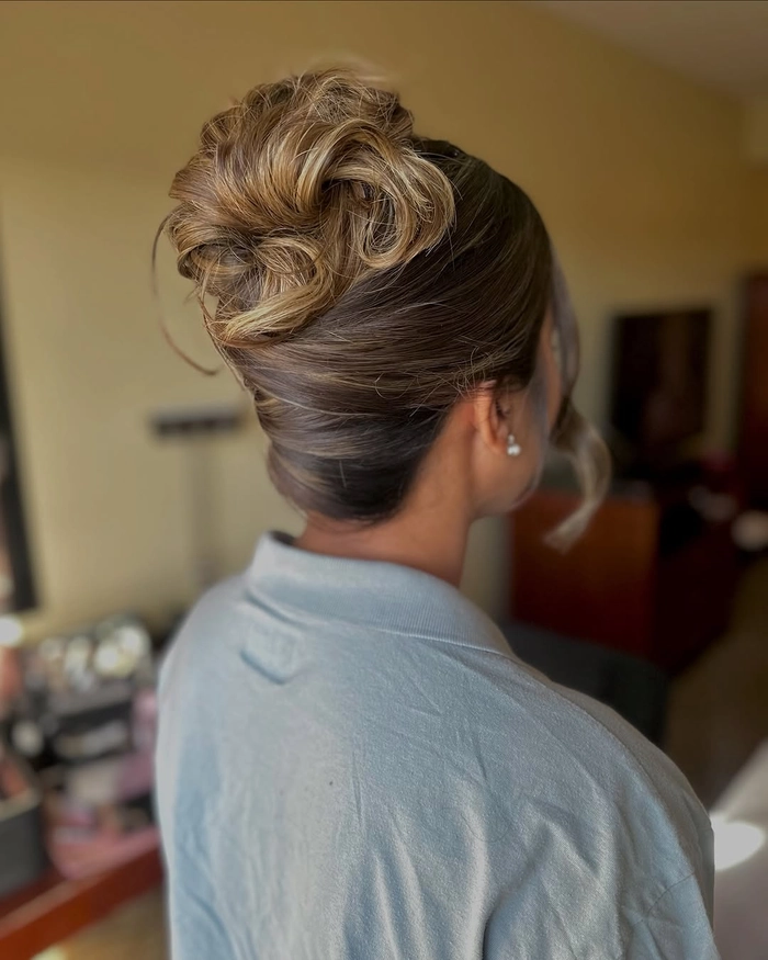 Messy french twist prom hairstyle with loose curls and wispy strands