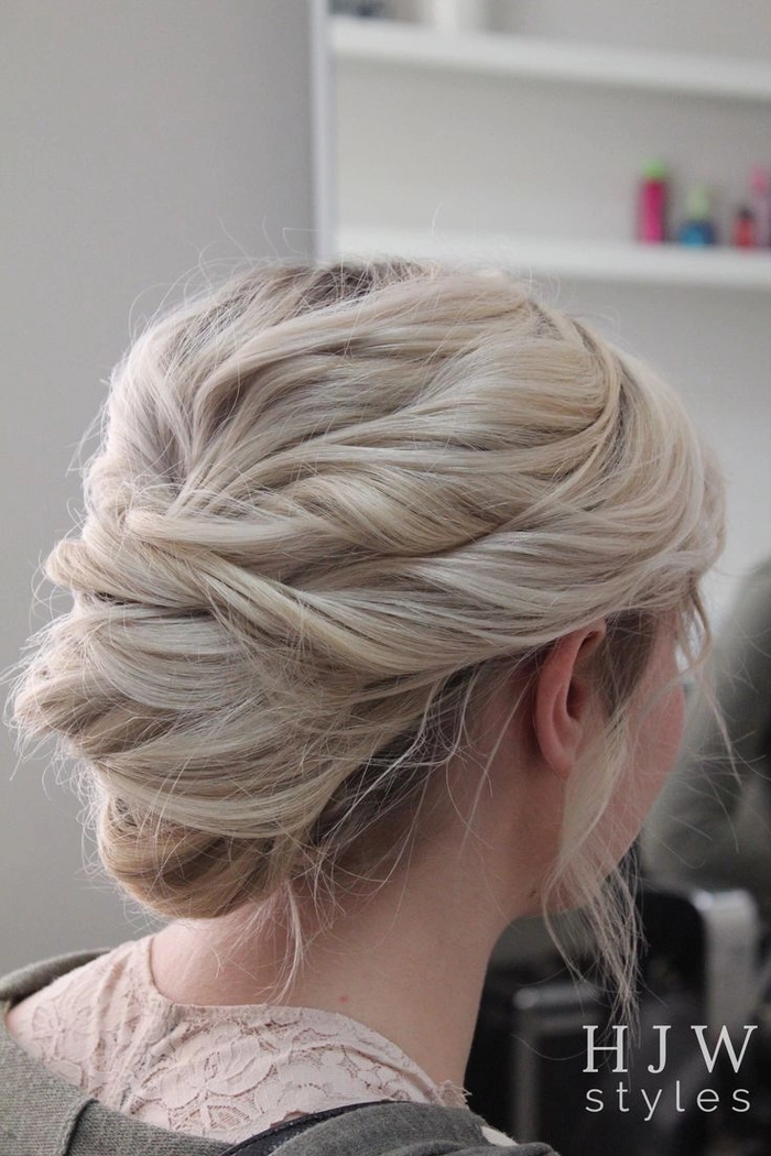 Messy French twist prom hairstyle with loose tendrils and volume