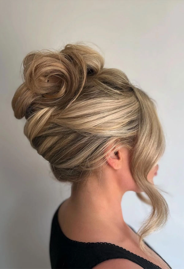 Messy French twist prom hairstyle with loose tendrils and volume