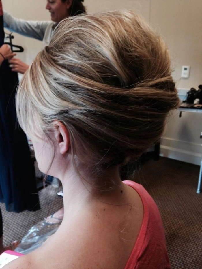 Messy French twist prom hairstyle with loose curls and volume