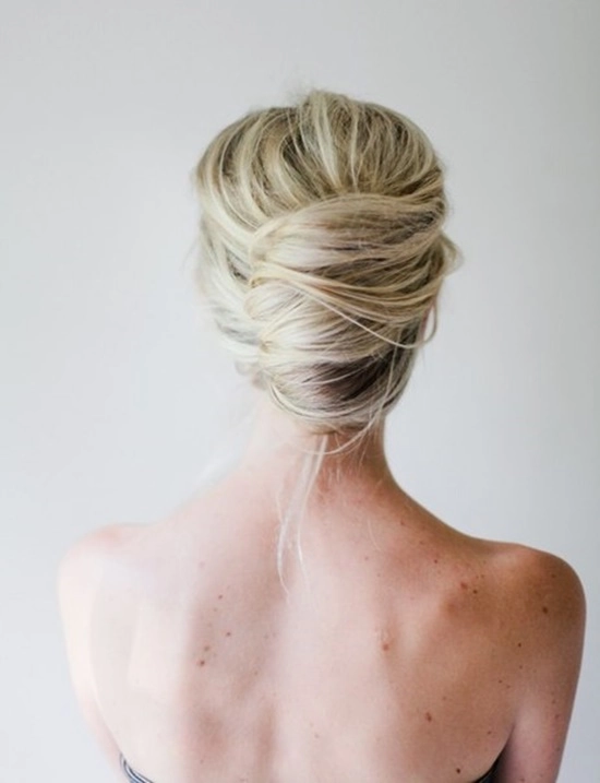 Messy French twist prom hairstyle with loose curls and tendrils