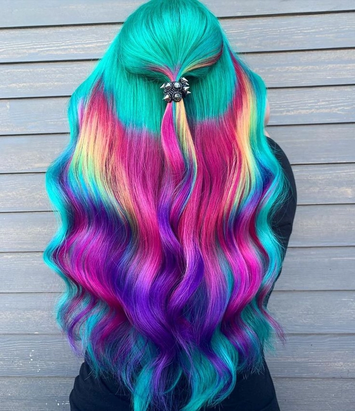 Prom hairstyle featuring vivid rainbow colored hair styled in loose curls for prom night