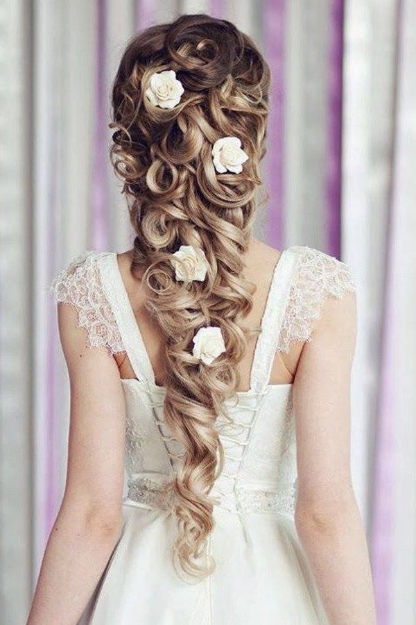 Elegant romantic fairy tale princess prom hairstyle with soft curls and floral accents