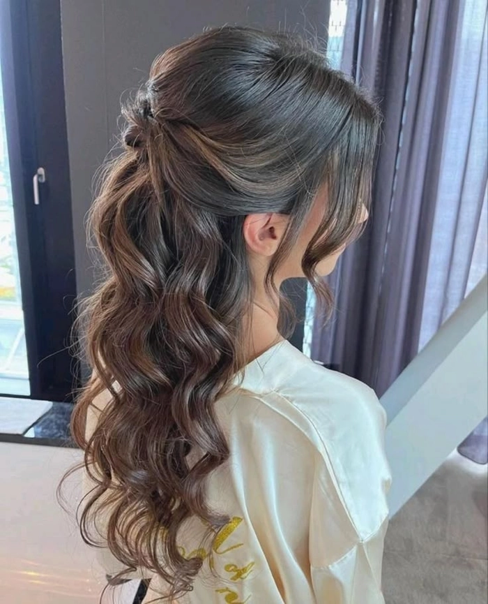 Elegant romantic fairy tale princess prom hairstyle with soft curls and floral accessories