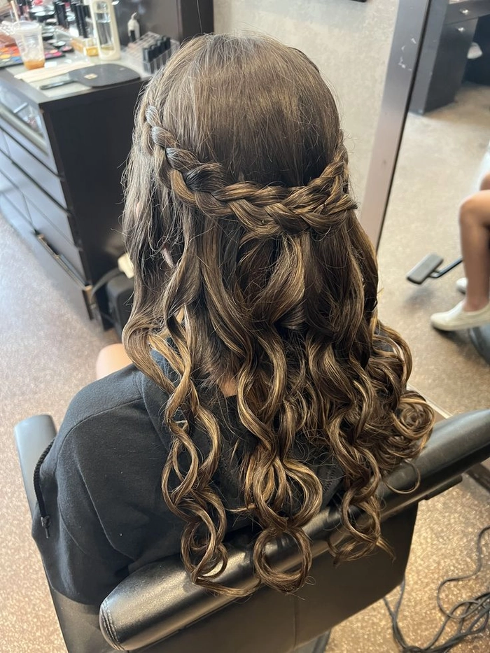Prom hairstyle inspiration featuring a chic and polished look for sweet sixteen events Elegant sweet sixteen formal hairstyle with loose curls and floral accessories
