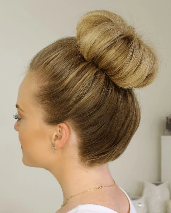 Gorgeous textured top knot hairstyle perfect for prom night glamour Textured top knot prom updo with elegant volume and soft tendrils