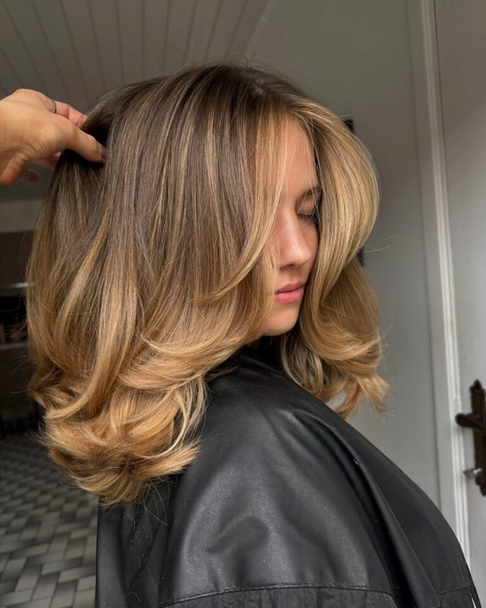 Voluminous blowout prom hairstyle with high volume and soft curls