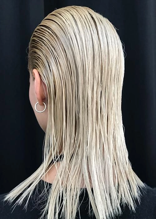 Wet look slicked back prom hairstyle on a young woman with elegant makeup