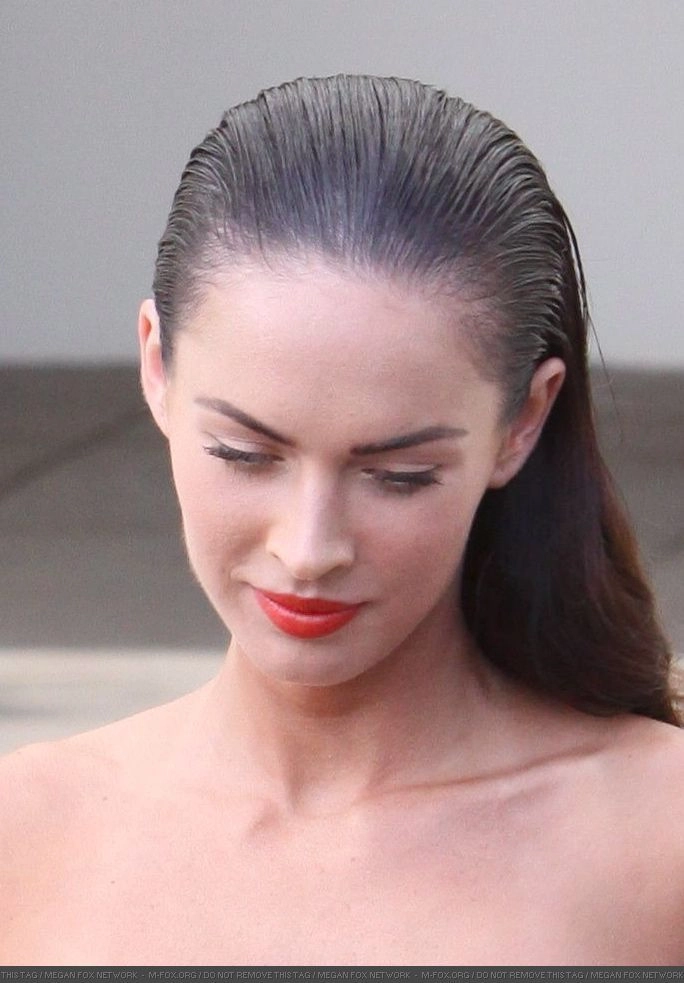 Wet look slicked back prom hairstyle with glossy finish and elegant waves