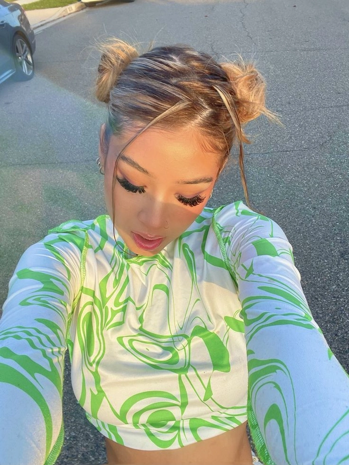 Y2K inspired space bun prom hairstyle with sleek baby hairs and glitter accents